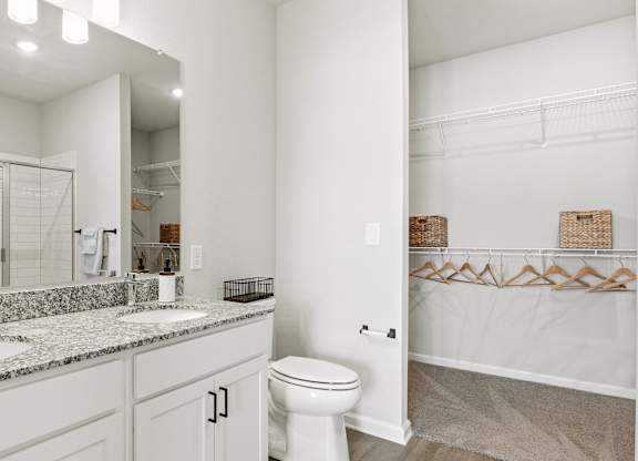 A white bathroom with a toilet, sink, and mirror.