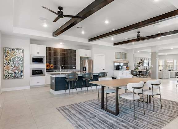 A modern open-plan living and dining area with a kitchen in the background.