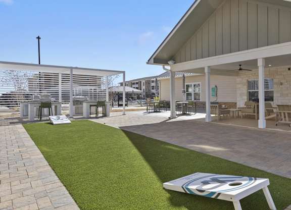 A patio area with a table and chairs under a roof.