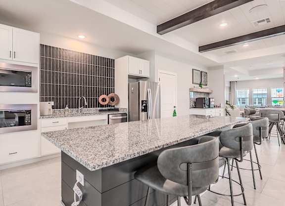 A modern kitchen with a granite countertop and stainless steel appliances.