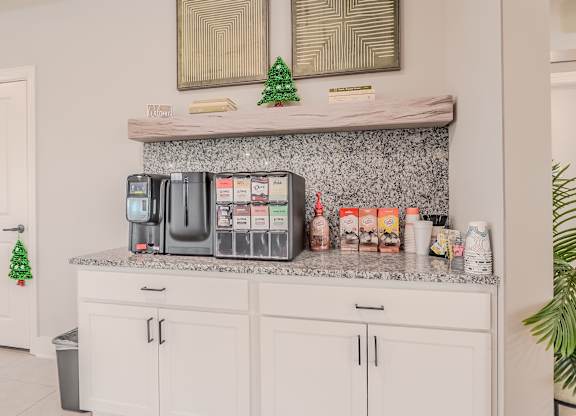 A kitchen counter with a variety of containers and a small Christmas tree.