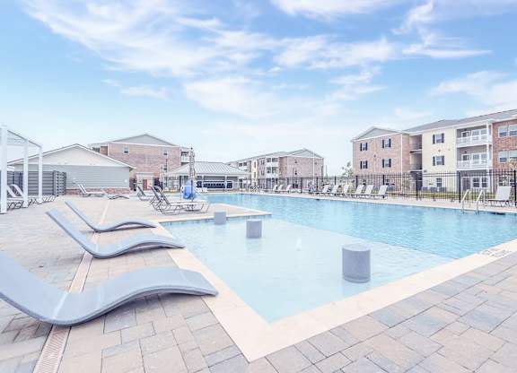 A swimming pool with a slide and a building in the background.