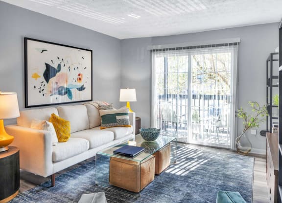 a living room with a couch and a coffee table and a sliding glass door at Station JTown, Louisville, KY, 40299