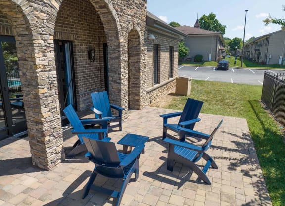 a patio with three blue adirondack chairs and a parking lot in the background at Enclave at Breckenridge Apartments, Louisville, 40220