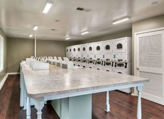 a large laundry room with a long table in the middle of it at Station JTown, Louisville