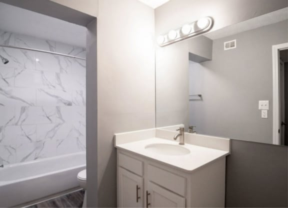 a bathroom with a sink and a bathtub at Station JTown, Louisville, KY 40299