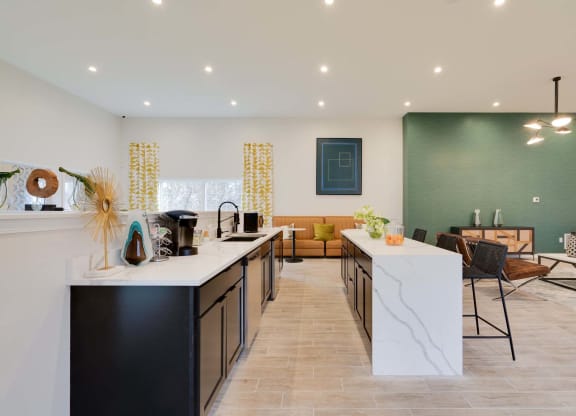 a kitchen with a long counter and a living room in the background at Station JTown, Louisville Kentucky