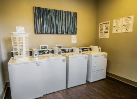 a row of washers and dryers in a room at Enclave at Breckenridge Apartments, Louisville, KY