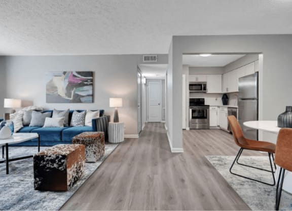 a living room with a couch table and chairs and a kitchen in the background at Enclave at Breckenridge Apartments, Louisville, KY, 40220