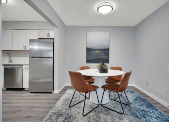 a dining room with a table and chairs and a refrigerator in the background at Enclave at Breckenridge Apartments, Louisville, 40220