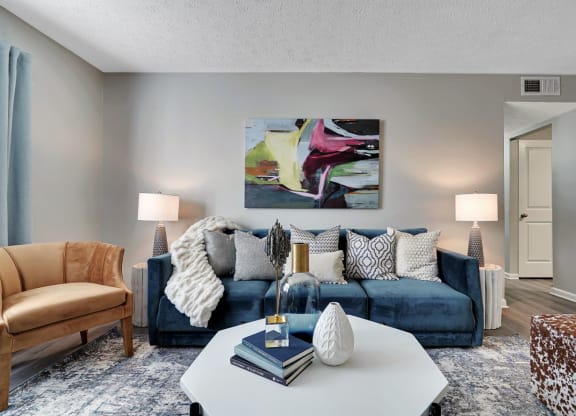 a living room with a blue couch and a white coffee table at Enclave at Breckenridge Apartments, Louisville, KY