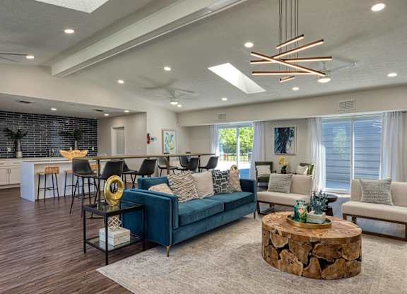 A modern living room with a dark blue sofa and a coffee table in the center.
