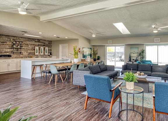 A modern living room with a kitchen area in the background.