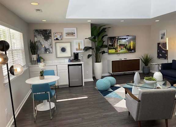 A modern living room with a white table and blue chairs.