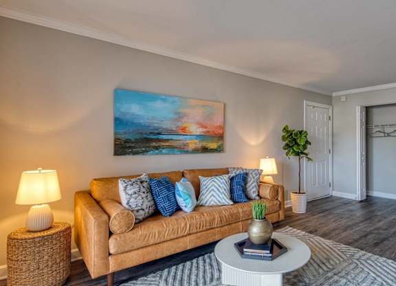 A living room with a couch, a side table, a coffee table, and a painting on the wall.