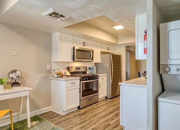 A small kitchen with white appliances and a white washing machine.