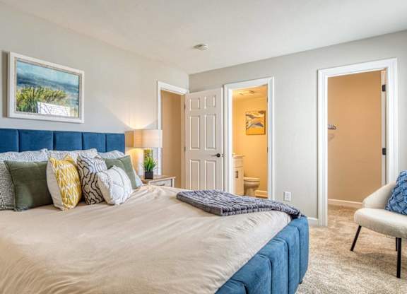 A bedroom with a large bed and a painting on the wall.