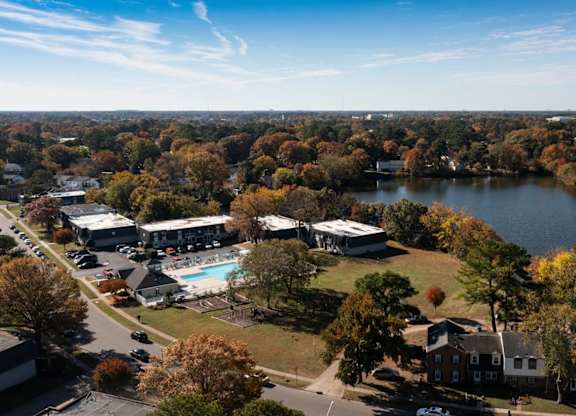 A large body of water surrounded by trees and buildings.
