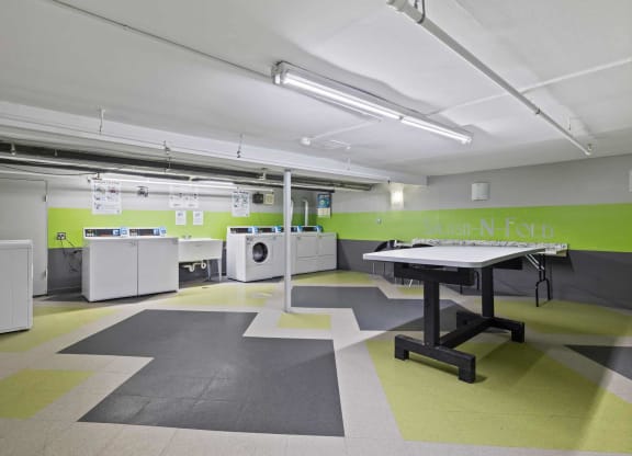 a large laundry room with washing machines and a table