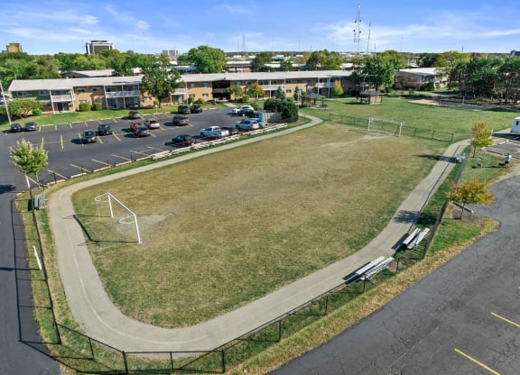 an aerial view of a park with a soccer field and a parking lot