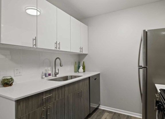 a kitchen with white cabinets and a stainless steel refrigerator