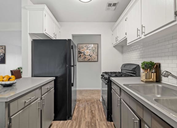 a kitchen with stainless steel appliances and a black refrigerator