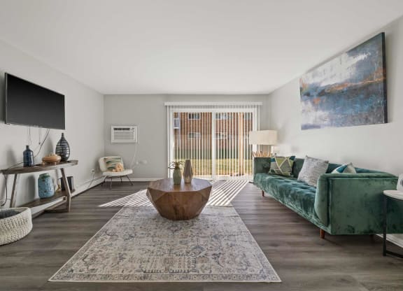 a living room with a green couch and a television