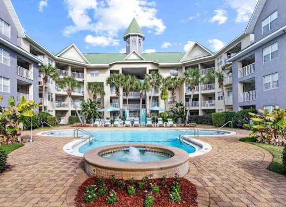 A large building with a green roof and a pool in front.at Coastline Apartments, Fort Walton Beach, FL 32547  