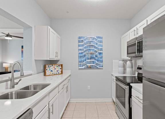 A kitchen with white cabinets and a stainless steel oven.at Elan Apartments, Fort Walton Beach, FL