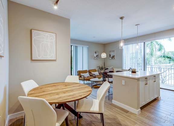 A dining room with a wooden table and chairs.