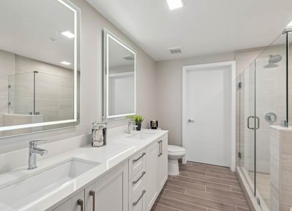 A bathroom with a white sink, mirror, and toilet.