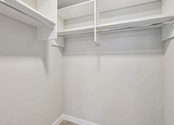 A white empty room with a shelf on the wall.