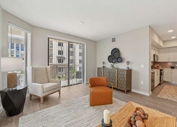 A living room with a sofa, chairs, and a rug.