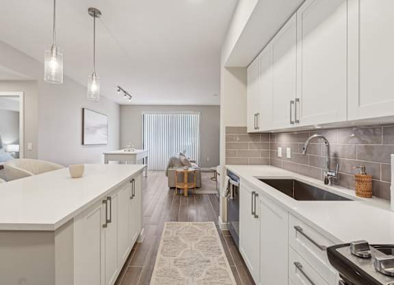 A modern kitchen with white cabinets and a large island.