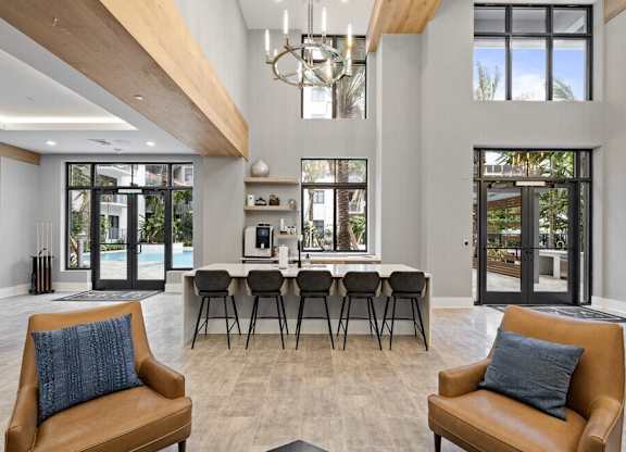 a living room with a bar and chairs and a kitchen with a pool at Mayla Pompano, Pompano Beach, 33062