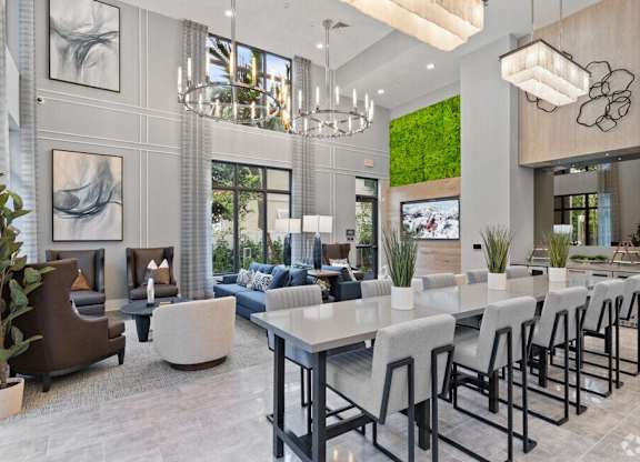 a dining room and living room with a long table and chairs at Mayla Pompano, Pompano Beach, FL