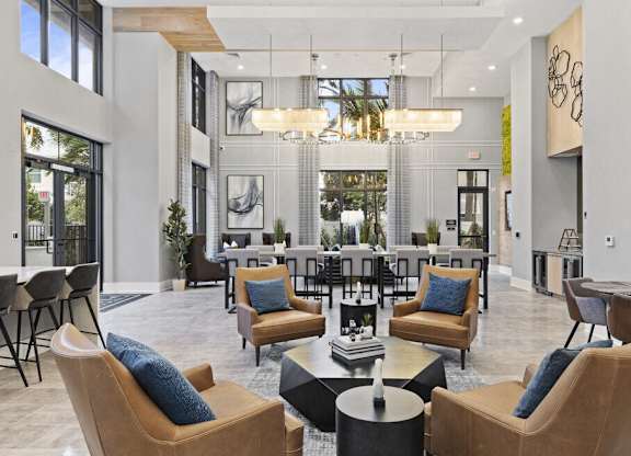 a living room with chairs and tables and a large window at Mayla Pompano, Pompano Beach, 33062