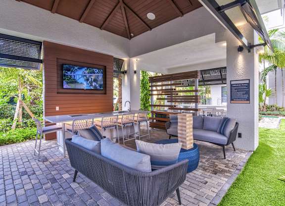 A patio with a grey couch and a wooden television at Mayla Pompano, Pompano Beach, 33062