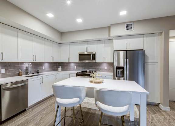 A modern kitchen with a white table and chairs.