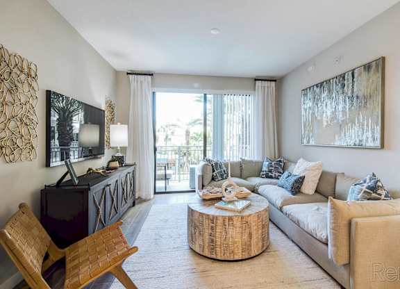 A living room with a wooden chair and a white couch at Mayla Pompano, Pompano Beach, 33062