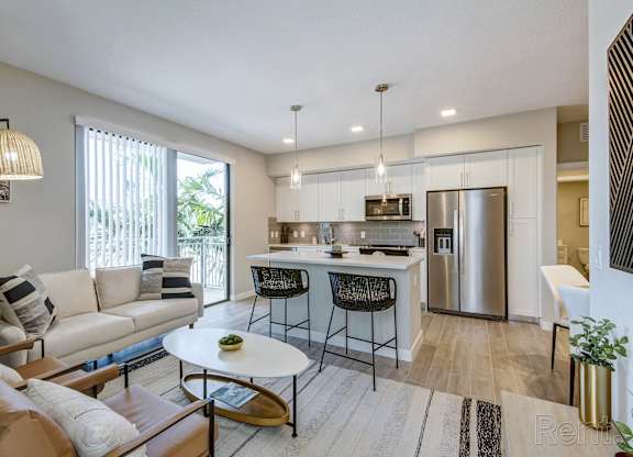 A modern kitchen with a breakfast bar and a dining table with chairs.