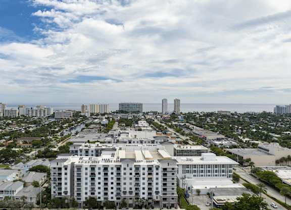 A large white building is in the center of a cityscape at Mayla Pompano, Pompano Beach, 33062