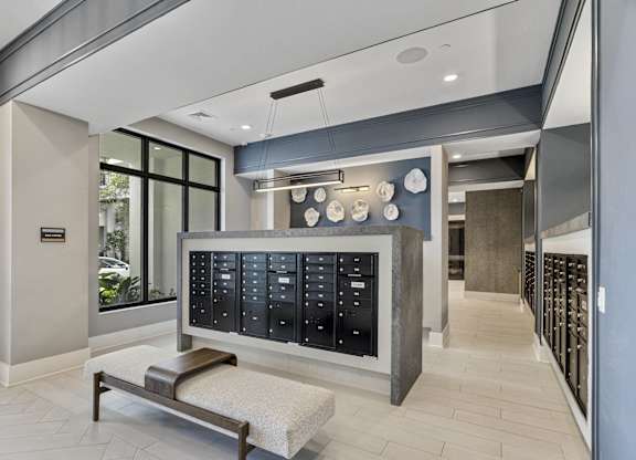 A modern waiting room with a bench and a wall of lockers at Mayla Pompano, Pompano Beach, Florida