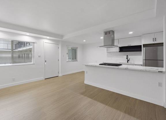 A kitchen with white cabinets and a wooden floor. at Torrance Gateway Apartments, California, 90501