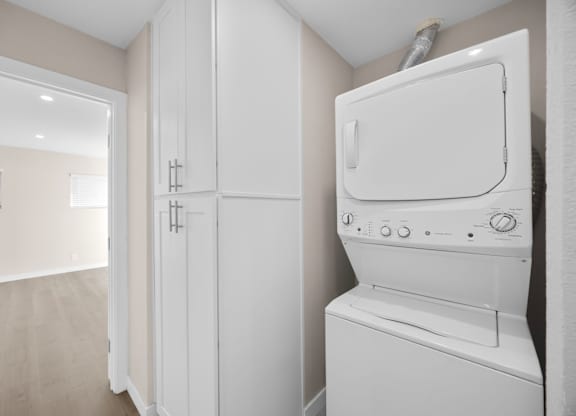 A white dryer is sitting in a laundry room.