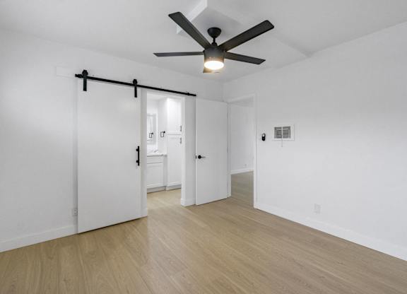 A room with a ceiling fan and wooden flooring. at Torrance Gateway Apartments, Torrance, California
