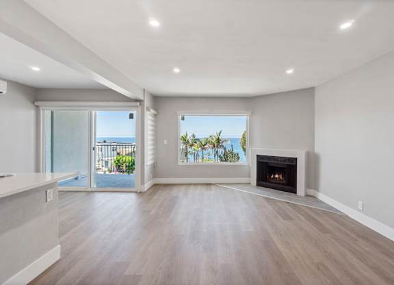 A spacious living room with a fireplace and sliding glass doors leading to a balcony.