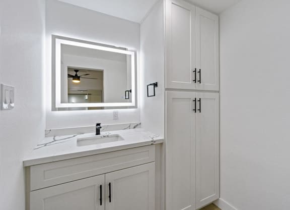 A bathroom with a white sink and a mirror. at Torrance Gateway Apartments, California, 90501