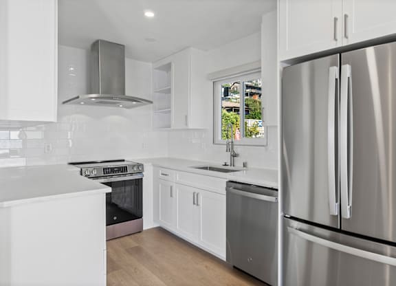 A modern kitchen with white cabinets and stainless steel appliances.at Ocean Edge @ Laguna Beach, Laguna Beach, CA 92651