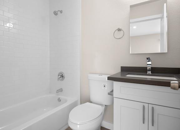 A white bathroom with a toilet, sink, and tub.